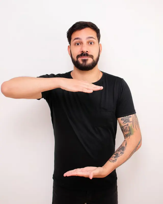 Thiago com as mãos na horizontal, uma acima da outra, segurando entre elas uma etiqueta de preço